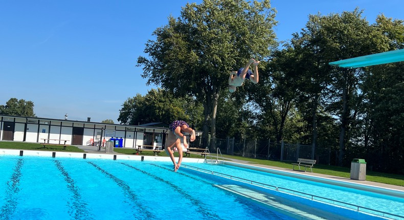 Hammenhögs friluftsbad med sin 25- metersbassäng och två trampoliner, varifrån två barn hoppar.